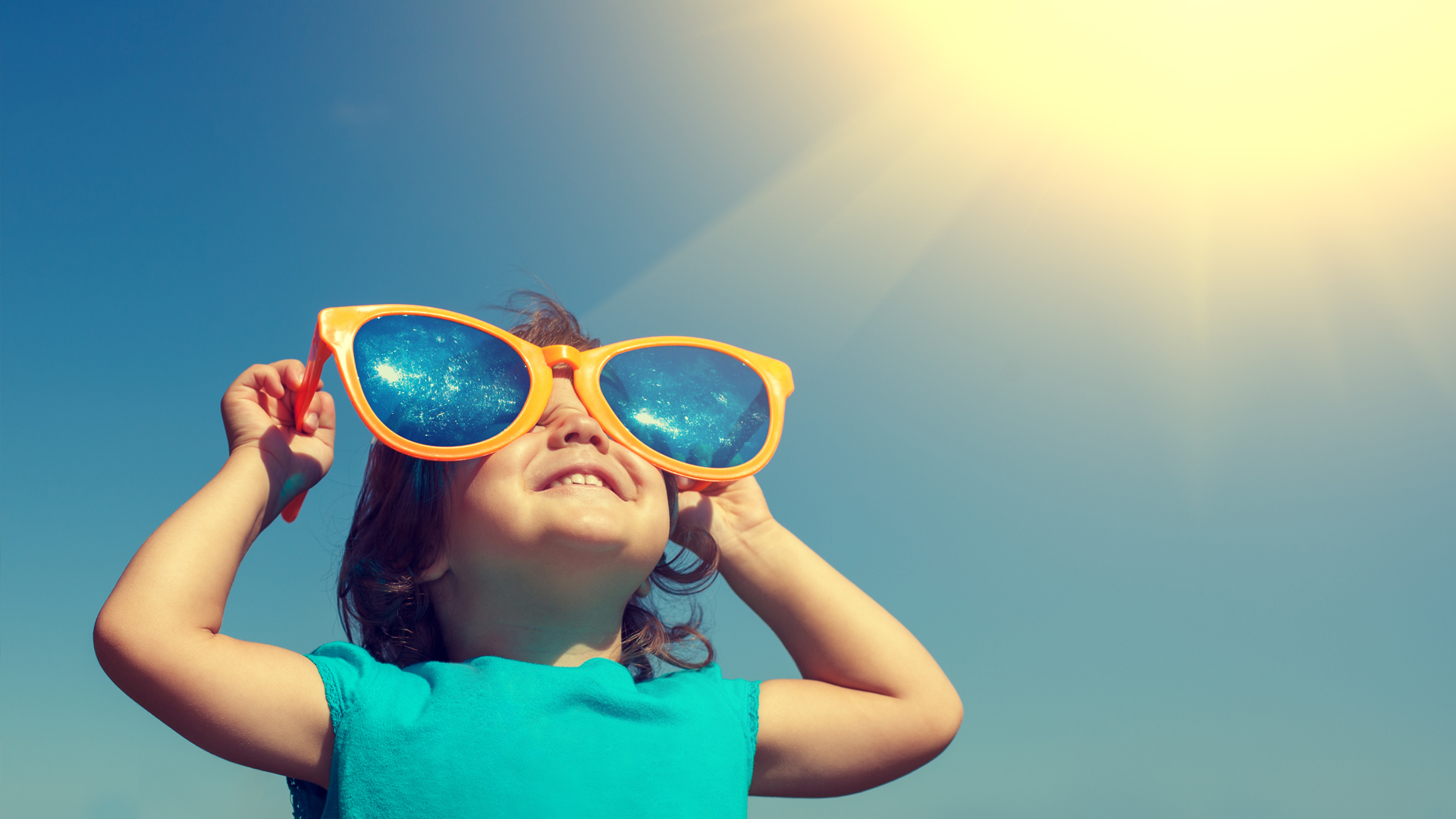 Little girl with shades looking at sun